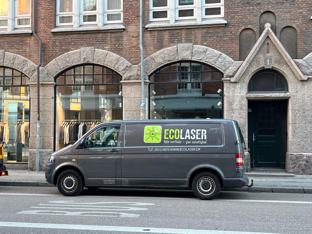 Firmabil ved afrenset facade i granit indre københavn