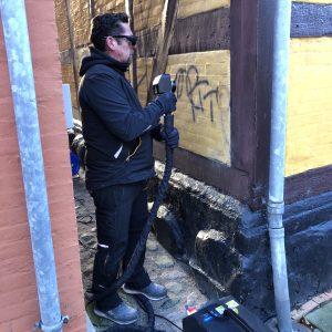 Ejeren af ecolaser fjerner graffiti med laser fra pudset malet væg pa fredet bygning i Rudkobing.